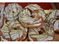 Profiteroles de rollo rellenos de nata y cubiertos de chocolate blanco